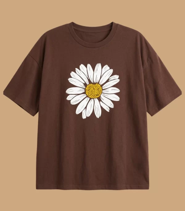 Woman wearing oversized brown daisy print t-shirt with white denim shorts, casual streetwear style