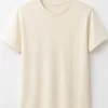 "Woman wearing oversized cream cotton t-shirt with brown cargo pants, minimal casual outfit"