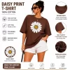 Woman wearing oversized brown daisy print t-shirt with white denim shorts, casual streetwear style