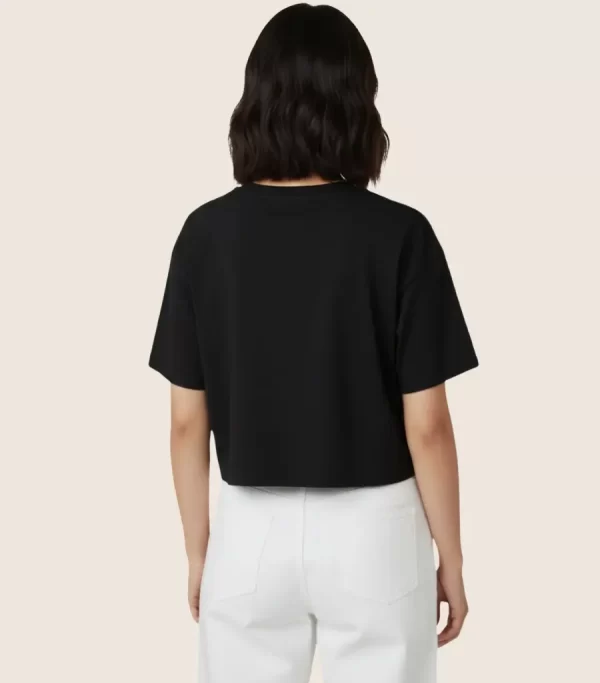Woman wearing black cropped t-shirt with cute daisy sunglasses graphic design, paired with white pants