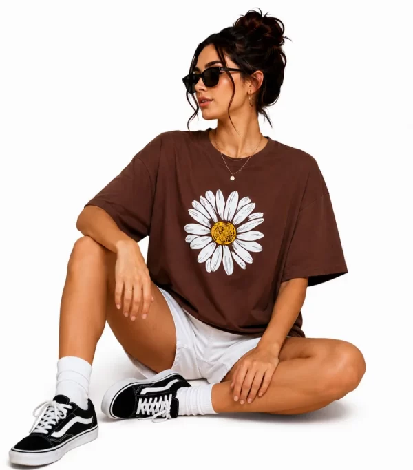 Woman wearing oversized brown daisy print t-shirt with white denim shorts, casual streetwear style