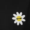 Woman wearing black cropped t-shirt with cute daisy sunglasses graphic design, paired with white pants