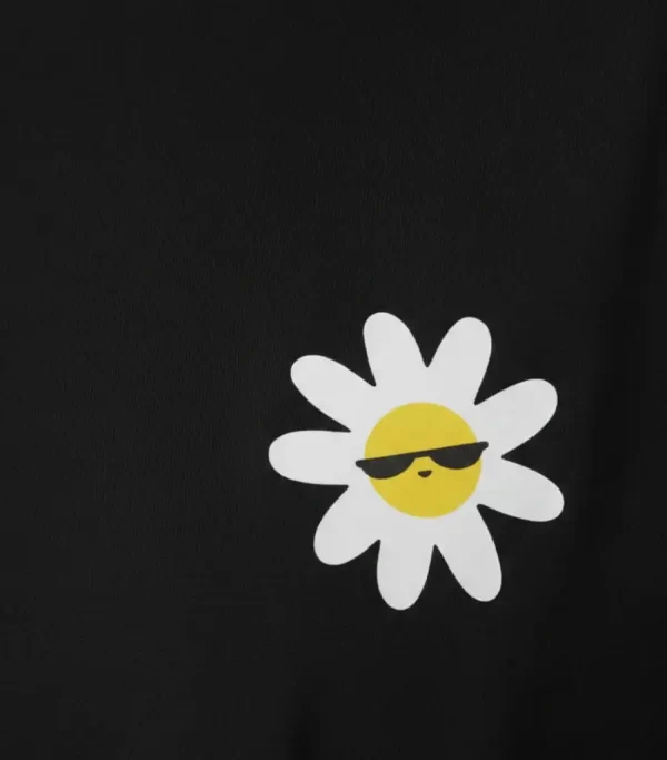 Woman wearing black cropped t-shirt with cute daisy sunglasses graphic design, paired with white pants