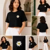 Woman wearing black cropped t-shirt with cute daisy sunglasses graphic design, paired with white pants