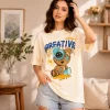 Woman wearing cream oversized t-shirt with Creative Smile teddy bear streetwear graphic print