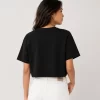 Woman wearing black oversized cropped t-shirt with boxy fit, paired with white jeans