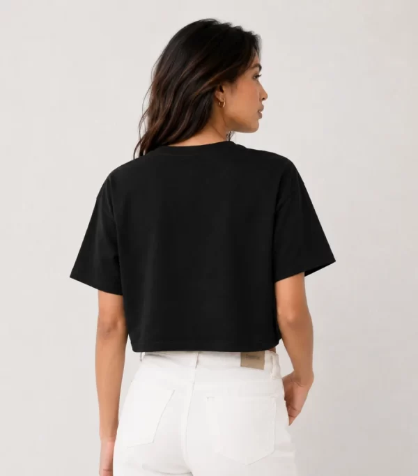 Woman wearing black oversized cropped t-shirt with boxy fit, paired with white jeans