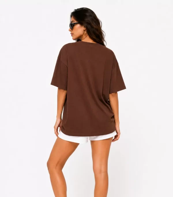 Woman wearing oversized brown cotton t-shirt with white shorts and sneakers, casual streetwear outfit