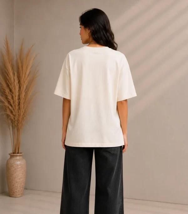 Woman wearing cream oversized t-shirt with Creative Smile teddy bear streetwear graphic print