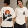 Woman wearing beige oversized t-shirt with Japanese ink-style mountain and red sun print on back, 'Find Peace Within' text with medallion graphic on front