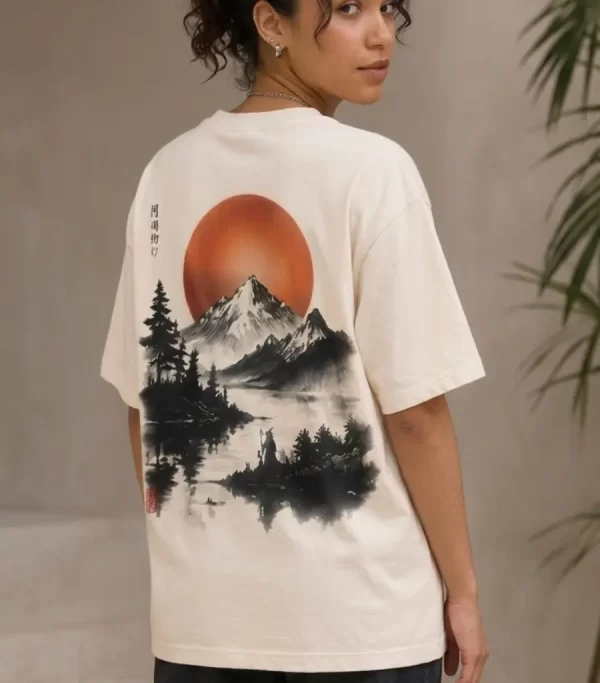 Woman wearing beige oversized t-shirt with Japanese ink-style mountain and red sun print on back, 'Find Peace Within' text with medallion graphic on front