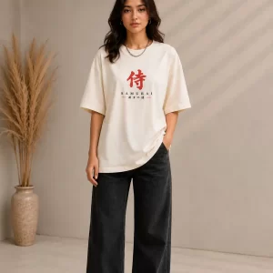 Woman wearing beige oversized Samurai graphic t-shirt with red Japanese kanji print, paired with black wide-leg jeans front and back view
