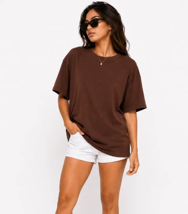 Woman wearing oversized brown cotton t-shirt with white shorts and sneakers, casual streetwear outfit