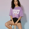 Lavender Moon Child graphic print t-shirt styled with black denim shorts and black and white sneakers, aesthetic flat lay outfit