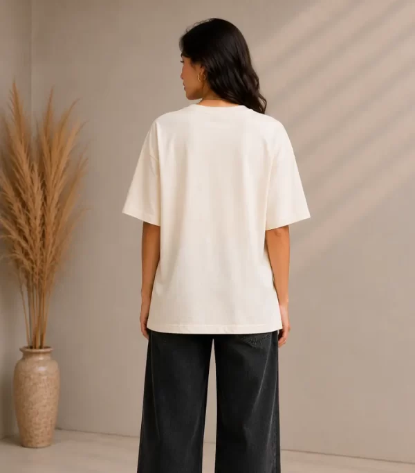 Woman wearing beige oversized Samurai graphic t-shirt with red Japanese kanji print, paired with black wide-leg jeans front and back view