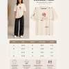 Woman wearing beige oversized Samurai graphic t-shirt with red Japanese kanji print, paired with black wide-leg jeans front and back view
