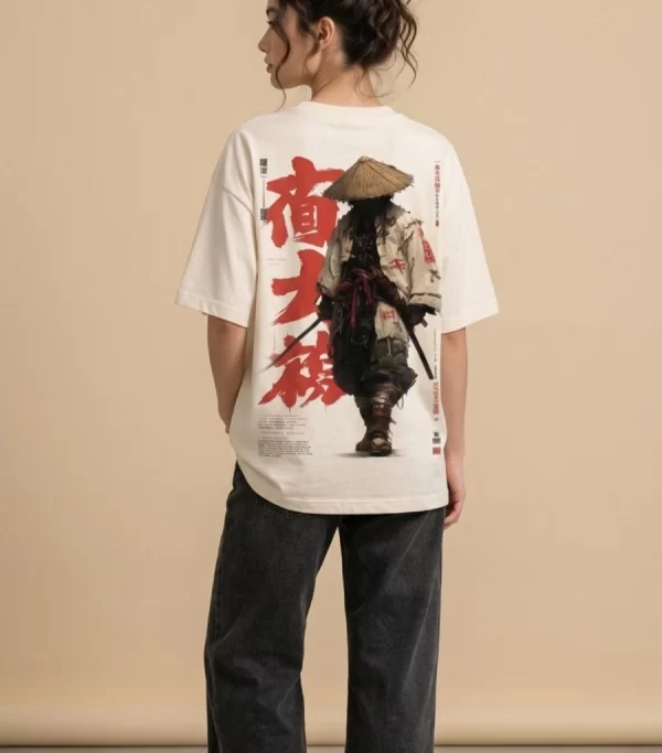 Woman wearing beige oversized t-shirt with samurai warrior illustration and red Japanese kanji print on back, 'SAMURAI' text print on front, styled with black wide-leg jeans