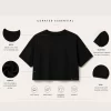 Woman wearing black oversized cropped t-shirt with boxy fit, paired with white jeans