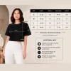 Woman wearing black oversized cropped t-shirt with boxy fit, paired with white jeans