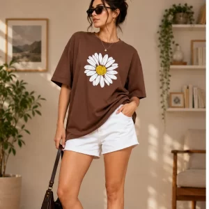 Woman wearing oversized brown daisy print t-shirt with white denim shorts, casual streetwear style