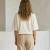 "Woman wearing oversized cream cotton t-shirt with brown cargo pants, minimal casual outfit"